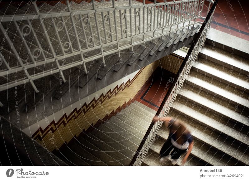 Young woman running down the antique staircase top view, royal vintage luxury style building and architecture background mystery fashion abstract retro playful