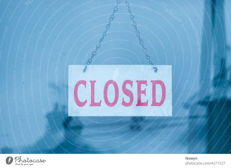 Closed sign with a reflection of snow covered houses advertising blue business close up closed closed  sign closeup cold comfort comforting communication detail
