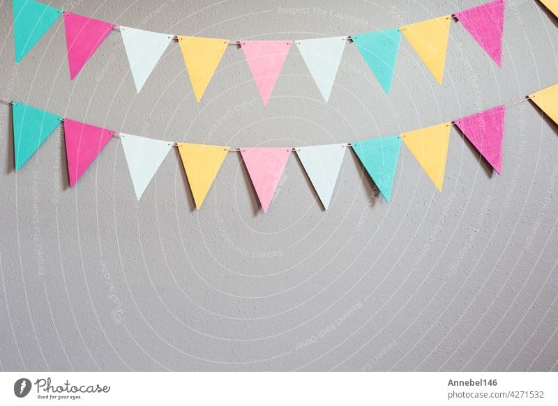 Colorful party flags over cement concrete gray wall texture background, pastel birthday colored flags with copy space Holiday concept happy music baby wedding