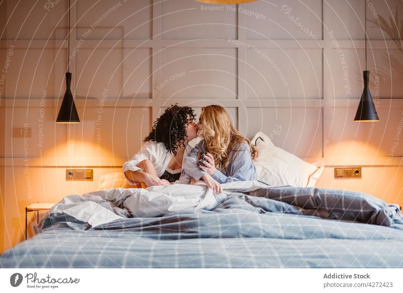 Lesbian couple hugging and kissing in bed women lesbian cuddle love morning tender affection female lgbt same sex unconventional gender carefree soulmate lover