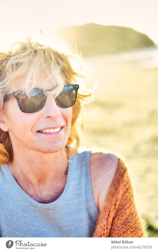 Portrait of a young mature blonde caucasian woman with sunglasses outdoor in a beach in a sunny day.  Lifestyle concept. lifestyle women relaxing travels