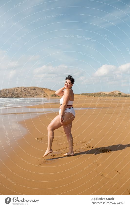 Woman standing on ocean water on sandy beach woman sea plus size swimsuit blue sky having fun shore alone female young foam tourist seashore harmony daytime