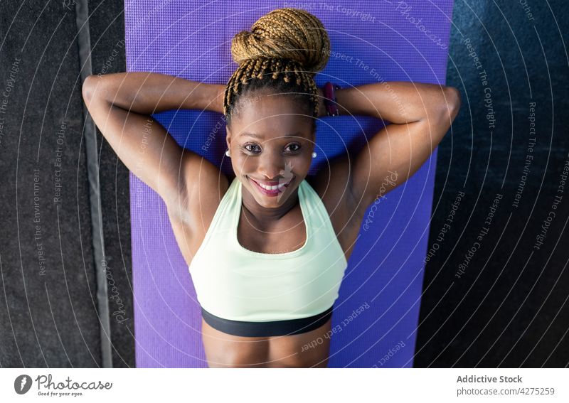 Full length of strong black athlete in sportswear running in neon