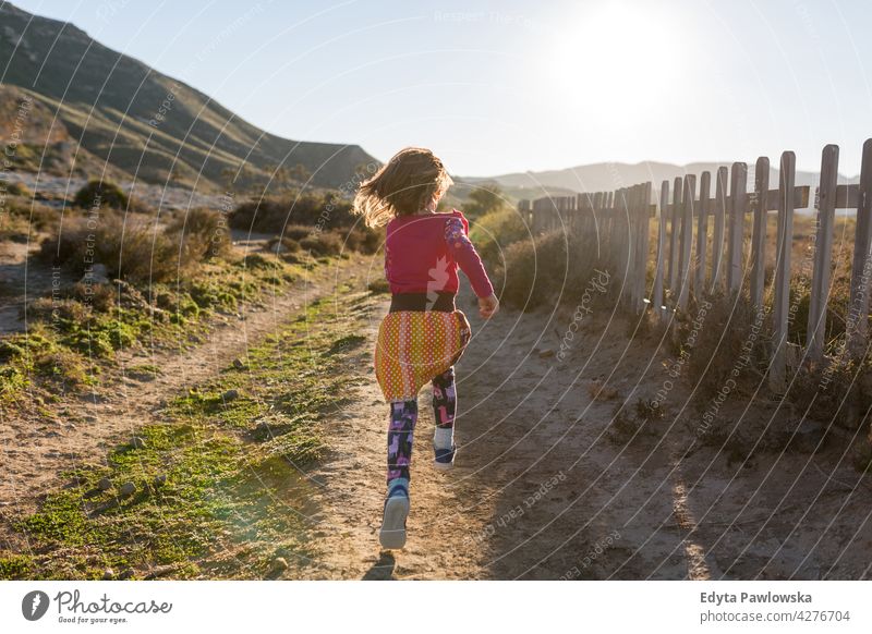 Little girl running through the Spanish landscape, Rambla del Playazo, Cabo de Gata - Nijar Natural Park, Spain national park Andalusia Iberian