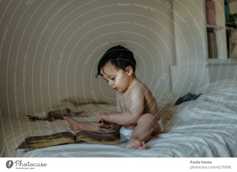 Child reading on the bed Boy (child) 1 - 3 years Caucasian at home Bed Bedroom Lifestyle Reading Book Authentic Home Infancy Family & Relations Cute people kid