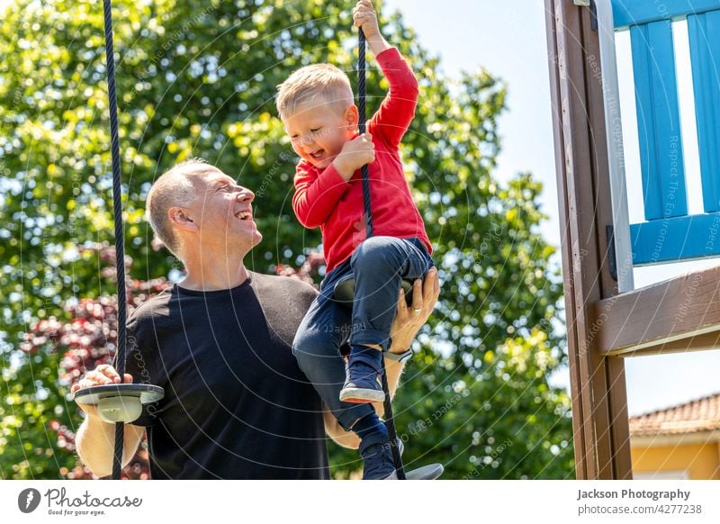 Father playing with his 3 years old son on the playground fun father kid toddler children kids portrait nature laughing bonding togetherness parenthood