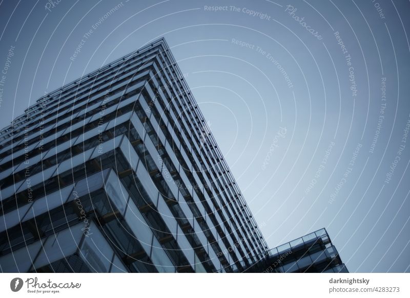 Modern architecture of a building for the administration and its activities in glass, steel and concrete at the evening blue hour Central perspective