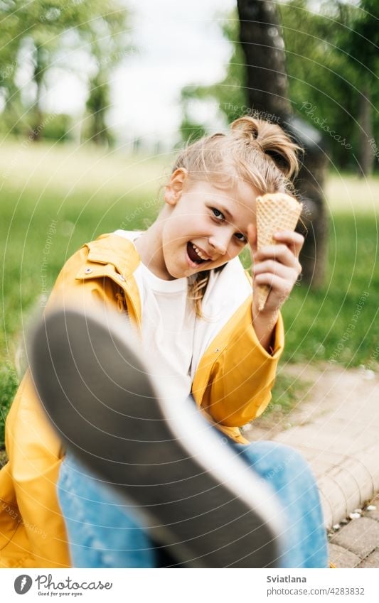 Portrait of a funny blonde teenage girl with ice cream on a walk in the park. Child outdoors summer teenager yellow trend happy cute child kid little dessert