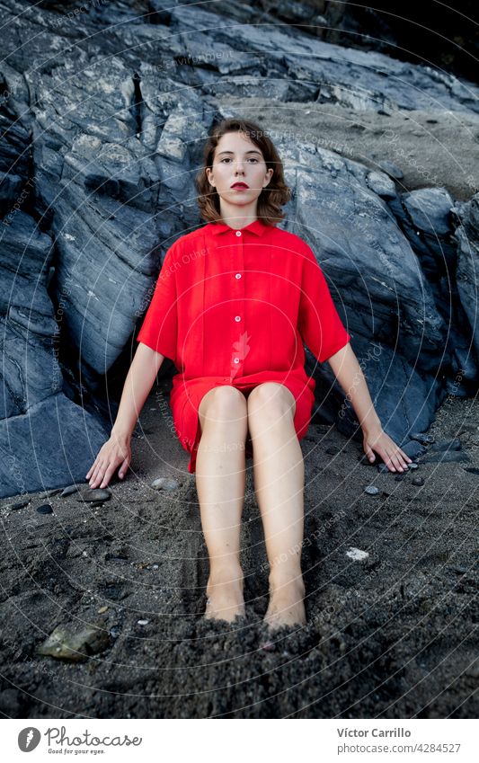 An elegant fashionable fresh beautiful woman in a red vintage dress with rocks background. portrait beauty young model hair face person cute wall smiling smile