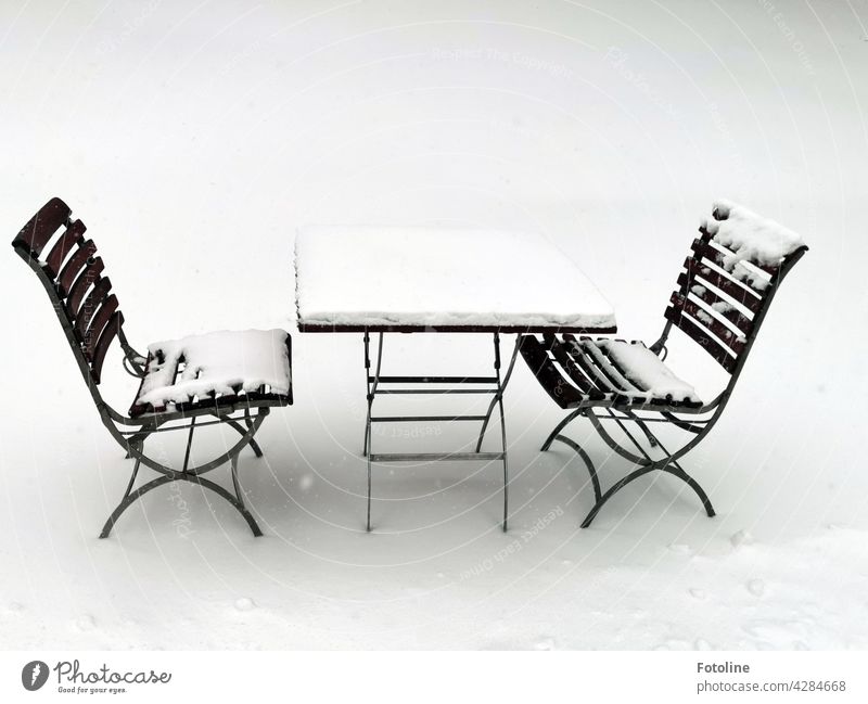 A cozy spot in the snow. 2 snow-covered chairs and a table are waiting for guests who need a little cooling down. Snow Winter Light Cold White Ice Frost Frozen