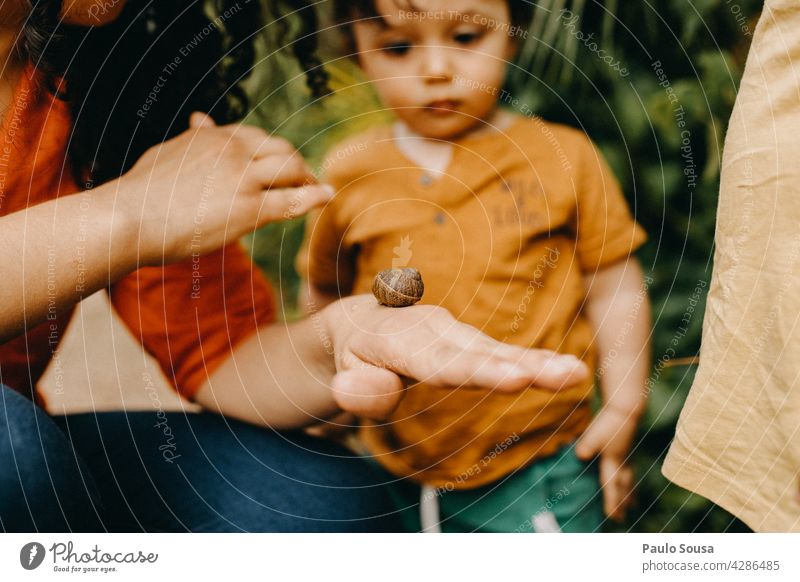 Mother shows snail to children motherhood Child Caucasian 1 - 3 years Snail Parents Cute Love Together Family & Relations togetherness people Infancy care Happy