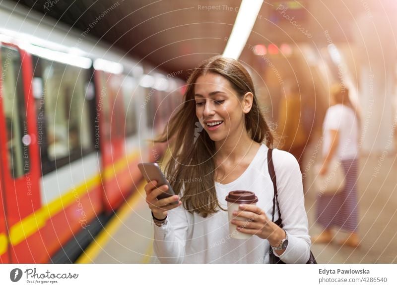Young woman at subway station people young adult casual attractive female smiling happy Caucasian toothy enjoying one person beautiful portrait positivity