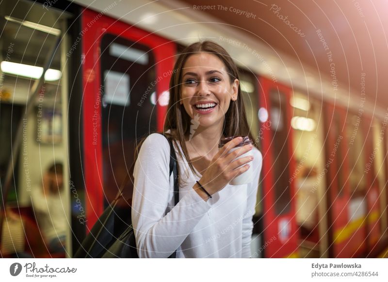 Young woman at subway station people young adult casual attractive female smiling happy Caucasian toothy enjoying one person beautiful portrait positivity