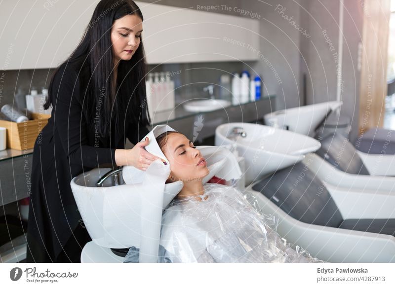 Hairdresser washing customer's hair enjoying lifestyle young adult people casual caucasian positive carefree happy smile smiling woman female attractive