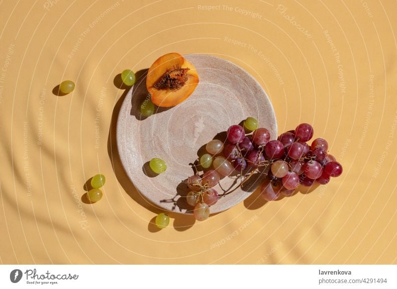 Sliced fresh peach and grape on homemade ceramic plate on yellow tablecloth, fruits catering grapes Fresh Diet Vitamin Summer Snack Peach Food Detox Plate