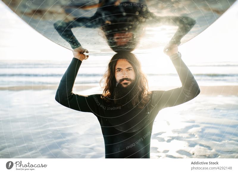 Surfer at the beach carrying surfboard man nature sunset wave outdoors portrait wetsuit seacoast male sportsman beard long hair surfing hobby surfer ocean