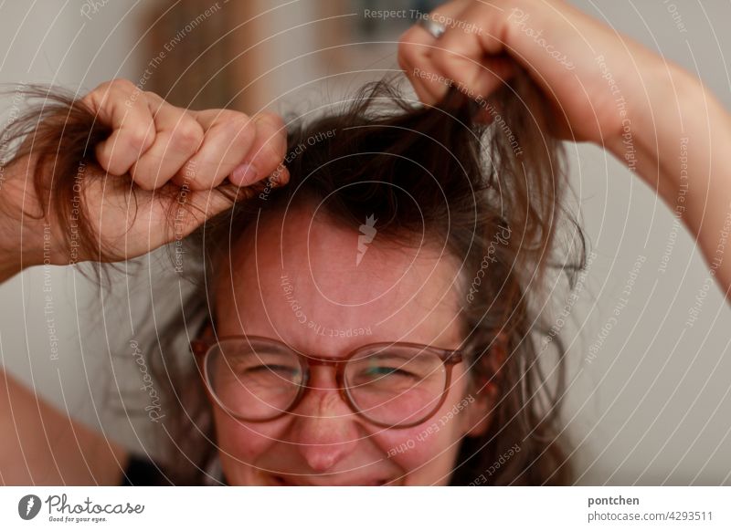 it's hair pulling. proverb. woman gets annoyed. grimaces Aggravation Anger emotion Proverb Woman Pull Brunette Eyeglasses Grimace Hideous Humor Face