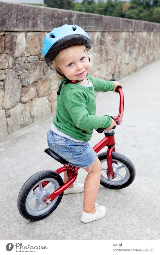 Little kid riding his bike down child bicycle summer baby little park safety happy toddler outside active ride sport helmet young outdoor fun wheels spring