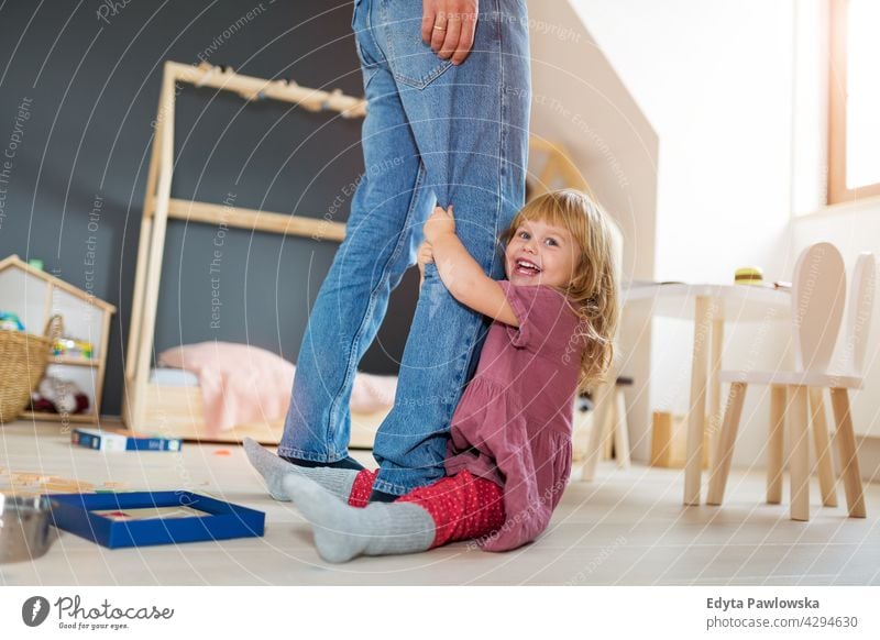 Little girl clutching father's legs home house man dad family parent relatives child daughter little girl kid kids children relationship together togetherness