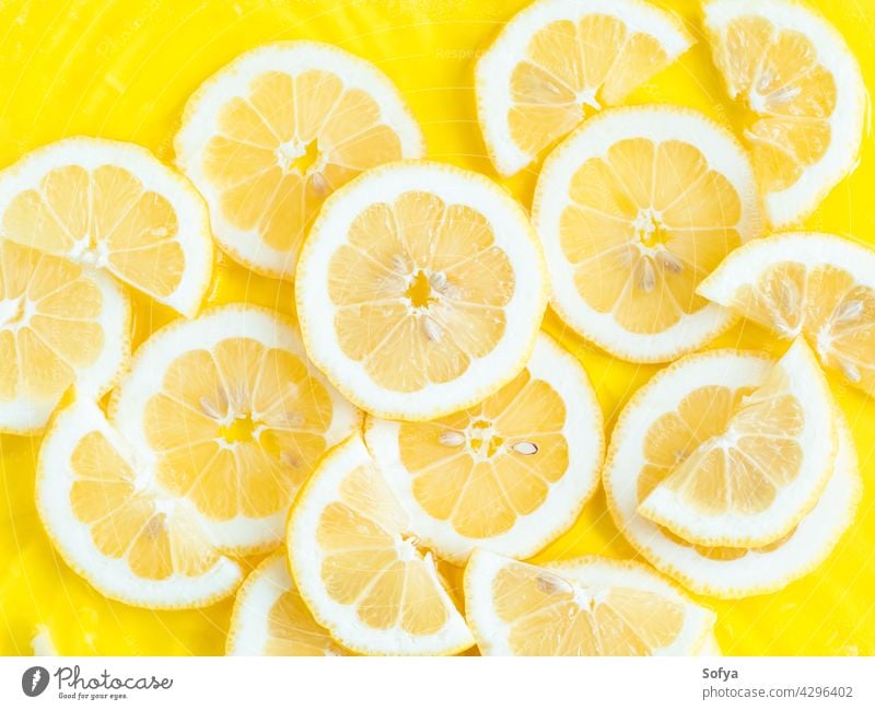 Lemon citrus slices in water with ripples, bold yellow texture summer background lemon fresh fruit food vitamin color pattern cut flatlay flat lay liquid