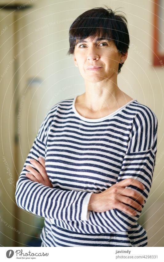 Middle-aged woman posing at home smiling at the camera with serenity. - a  Royalty Free Stock Photo from Photocase