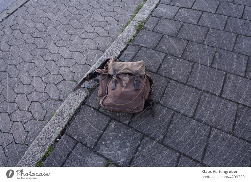 Brown backpack on the sidewalk Backpack off forsake sb./sth. Pastry Parking lot Forget Doomed