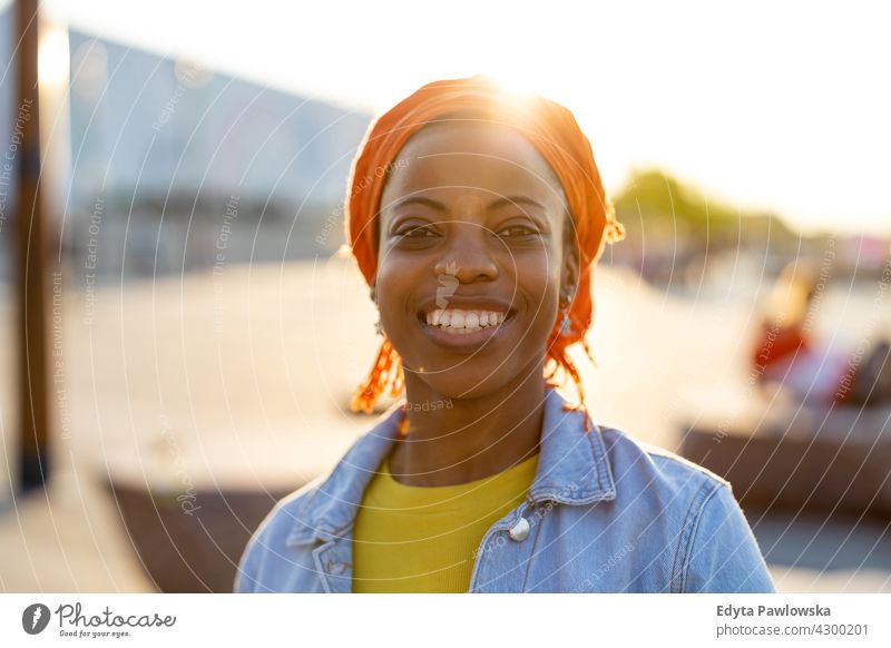 Portrait of smiling young woman in the city afro proud real people city life African american afro american student Black ethnicity sunny sunset outside pretty