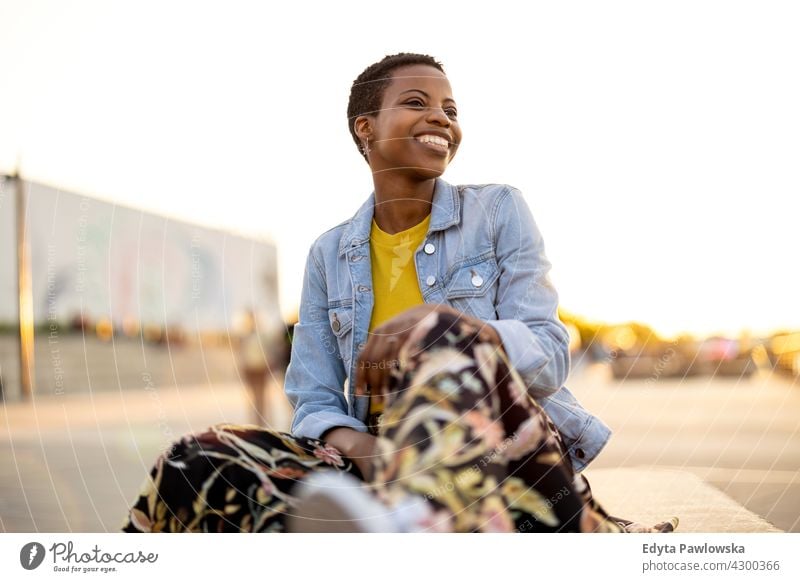 Smiling young woman enjoying the outdoors at sunset afro proud real people city life African american afro american student Black ethnicity sunny outside pretty