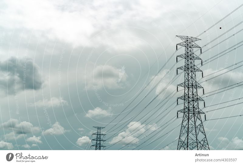High voltage electric pylon and electrical wire with grey sky and white clouds. Electricity poles. Power and energy concept. High voltage grid tower with wire cable. Infrastructure. Power distribution