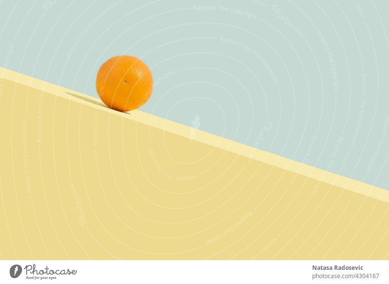 Summer orange fruit rolling downhill. Abstract concept Contemporary Rectangle Aesthetics Art background Blue Citrus fruits Colour colourful Copy Space
