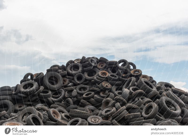 Old worn car tires piled up against a blue sky abandoned Auto automobile black care tire damage dirty disposal dump eco ecology environment environmental