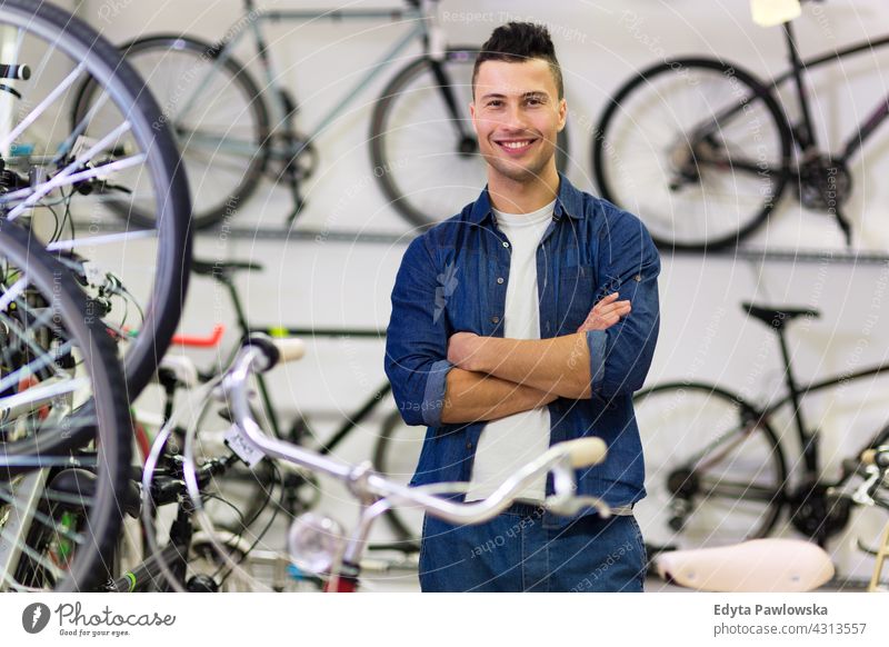 Man working in bike shop assistant bicycle bicycle mechanic bicycling bicyclist biking businessman buying commerce friendly help helpful indoors job manager