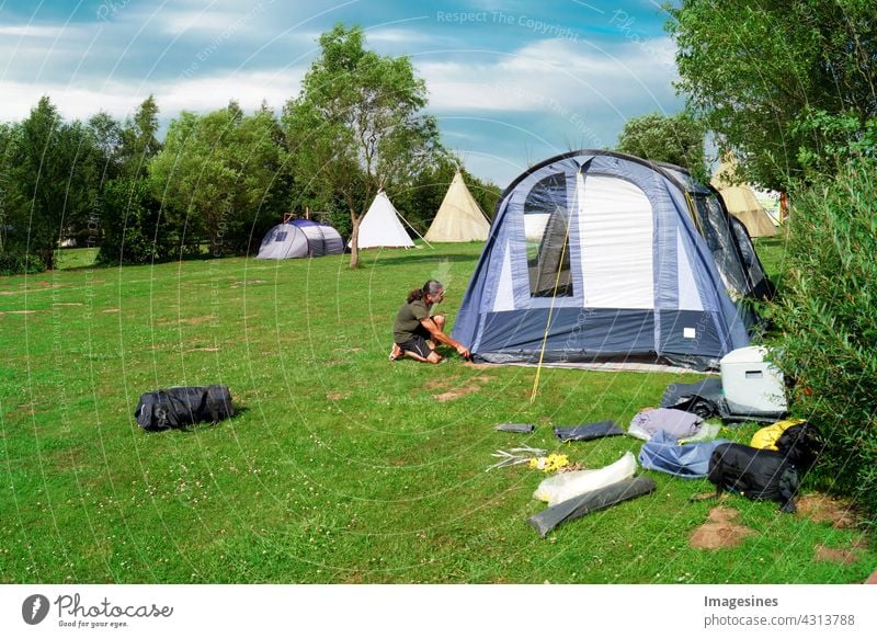 Camping - Camping. Man pitching a tent in a meadow in the summer active activity Adults Adventure Outdoors Lifestyle Summer Camping site Landscape Day gear