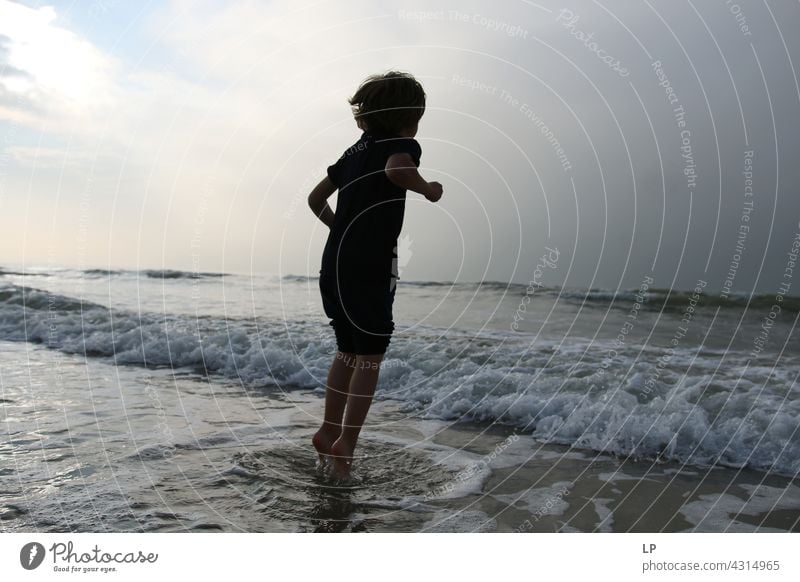 contrast silhouette of a child jumping in the sea outdoor recreation Structures and shapes Playing ocean beach Harmonious Well-being Neutral Background Day