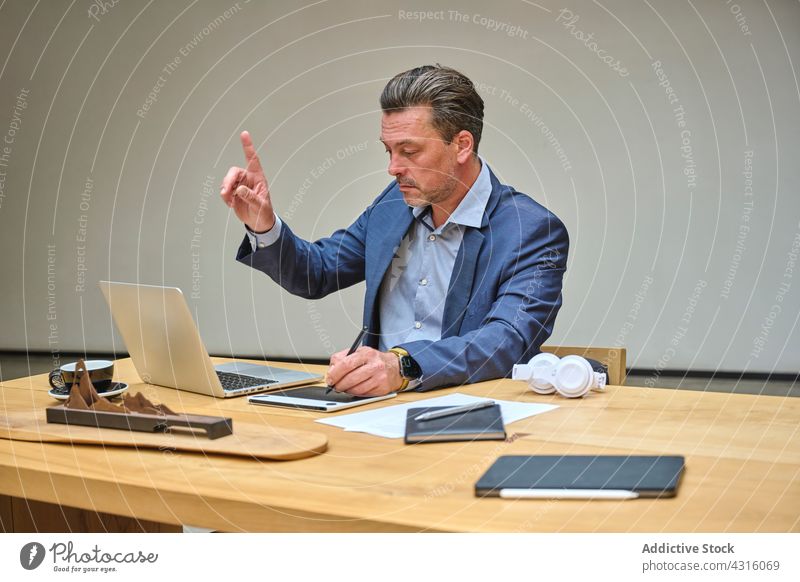 Designer at his office desk working on his laptop man coworking computer internet people table agency smartphone architect business businessman businesspeople