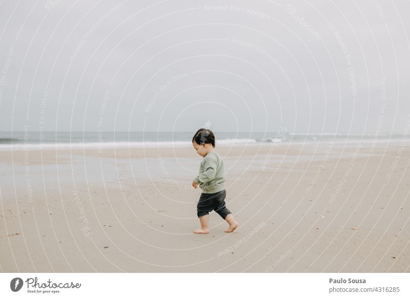 Child at the beach childhood Walking Sand Sandy beach Ocean Authentic Caucasian 1 - 3 years Exterior shot Playing Day Toddler Human being Lifestyle Joy Infancy