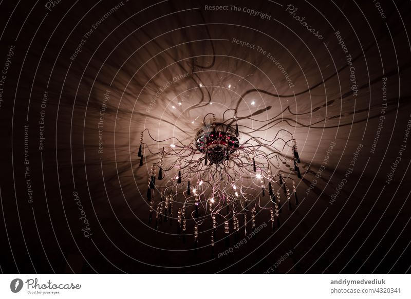 Chandelier.Home, beautiful chandelier.A luxurious lamp hangs from the ceiling. handelier with crystal.Chandelier ceiling lights, black background with copy space.Close Up.