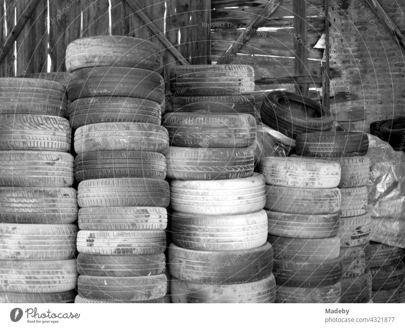 Stacked old car tires in front of a workshop in Adapazari in the province of Sakarya in Turkey, photographed in neo-realistic black-and-white. Tire Car tire