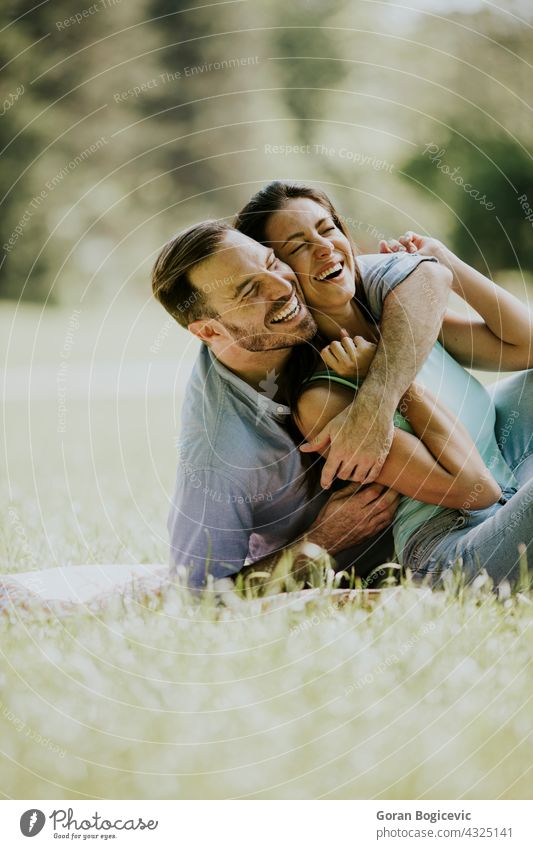 Affectionate young couple sitting on the green grass caucasian two summer day park together people woman happy smile spring beautiful happiness casual female