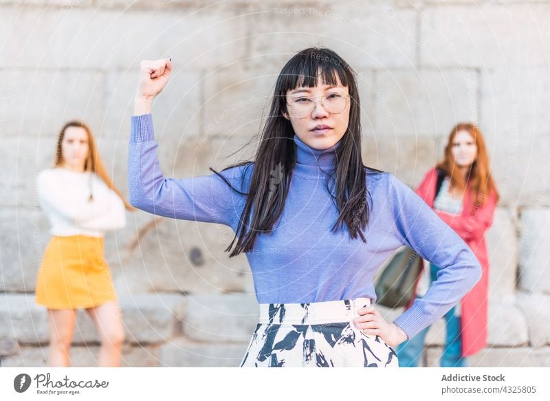 Company of powerful diverse women looking at camera strong girl power concept bicep confident asian ethnic company unity group determine female multiracial