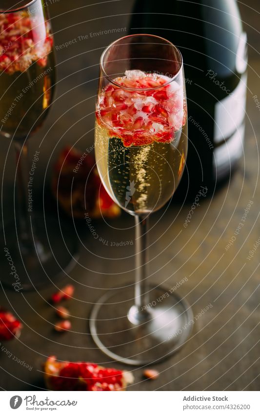Champagne cocktail with pomegranate alcohol background bartender beverage bokeh bubbles champagne cold drink food fresh fruit garnish glass mixologist mixology