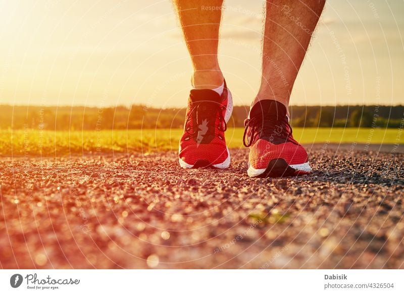 Runner man feet on road at the sunset run jog sneakers sport running foot fitness workout jogging sportsman summer outdoor nature weather evening runner