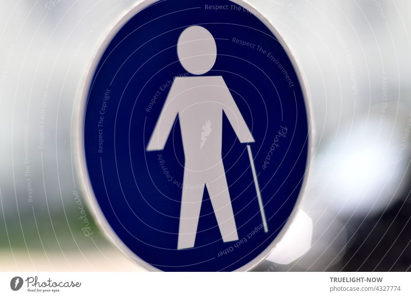 There's a man walking with a cane. He is white, around him only blue. What is missing is the woman. Pedestrian walkway Transport Road sign Blue White commanded