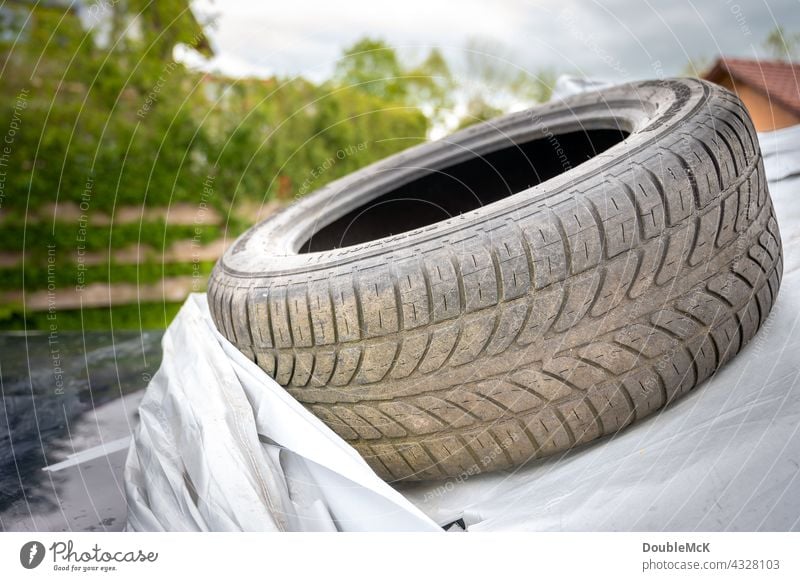 Dirty car tire lies on car tarp Car Vehicle Means of transport Transport Road traffic Motoring Colour photo Exterior shot Deserted Day Mobility Broken
