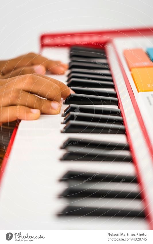Close-up of the fingers of a little kid playing in a red piano pianist person chord girl classical rythm create practicing performance melody creative closeup