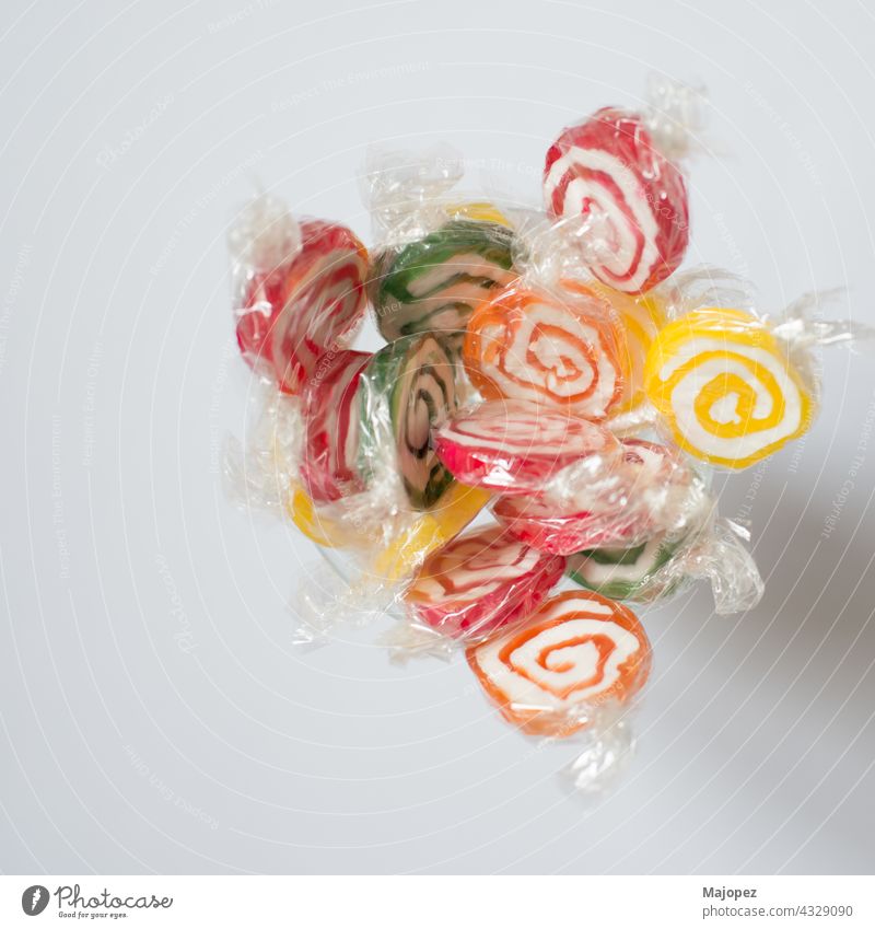 Handful of colorful lollipops seen from above. Red, green, yellow and orange. With white background candy child childhood circle colorful pattern concept
