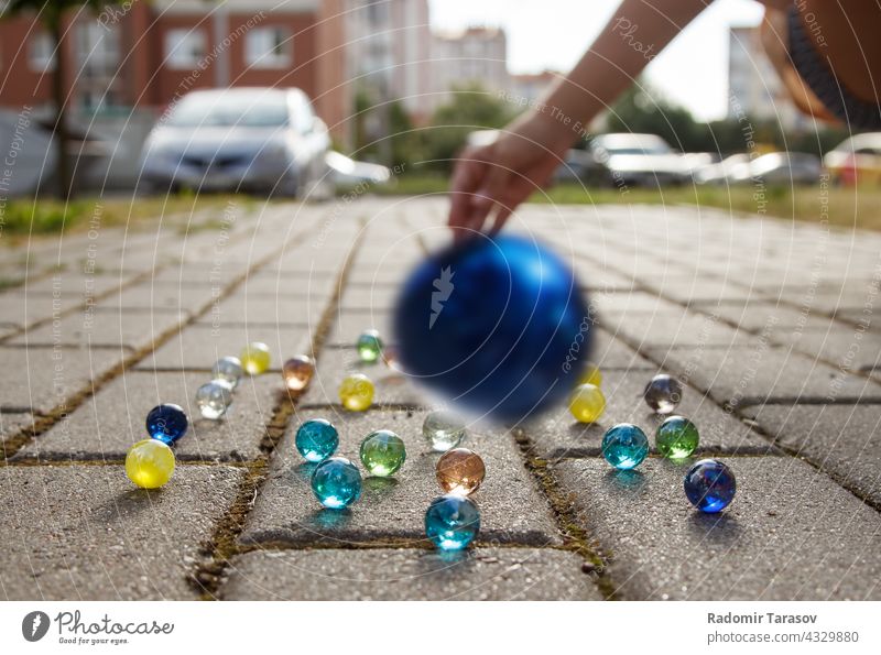 girl throws a glass ball on the sidewalk throwing play people fun game beautiful leisure activity entertainment yellow playful group playing child lane toys