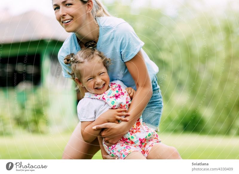 A young mother and her sweet little girl have fun in a sunny garden. The concept of a happy childhood and motherhood Baby Happy Garden mama Cute Mother Infancy