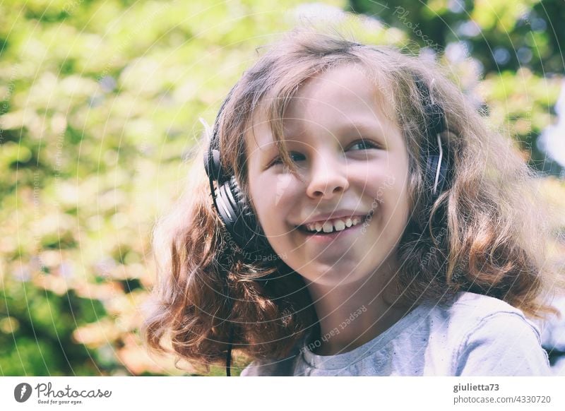 Portrait of a laughing 10 year old boy with long curly hair and headphones 10 years 11 years out Beautiful weather Laughter Happiness Funny Change naturally
