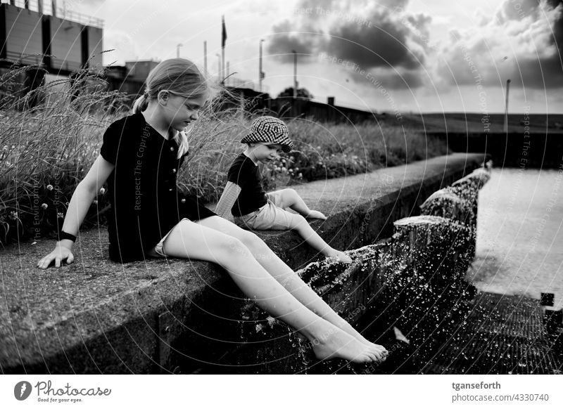 Children at the water children Water cooling Inject Cool feet quay wall dollar Drops of water Cooling Refreshment Swimming & Bathing Wet Summer Exterior shot
